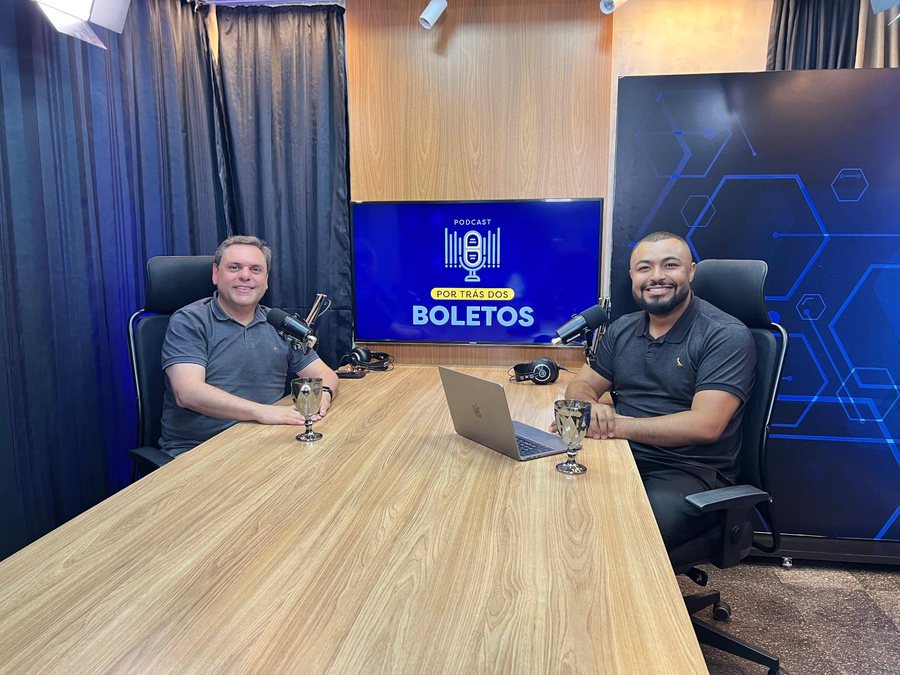 Host e convidado em estúdio com mesa de madeira